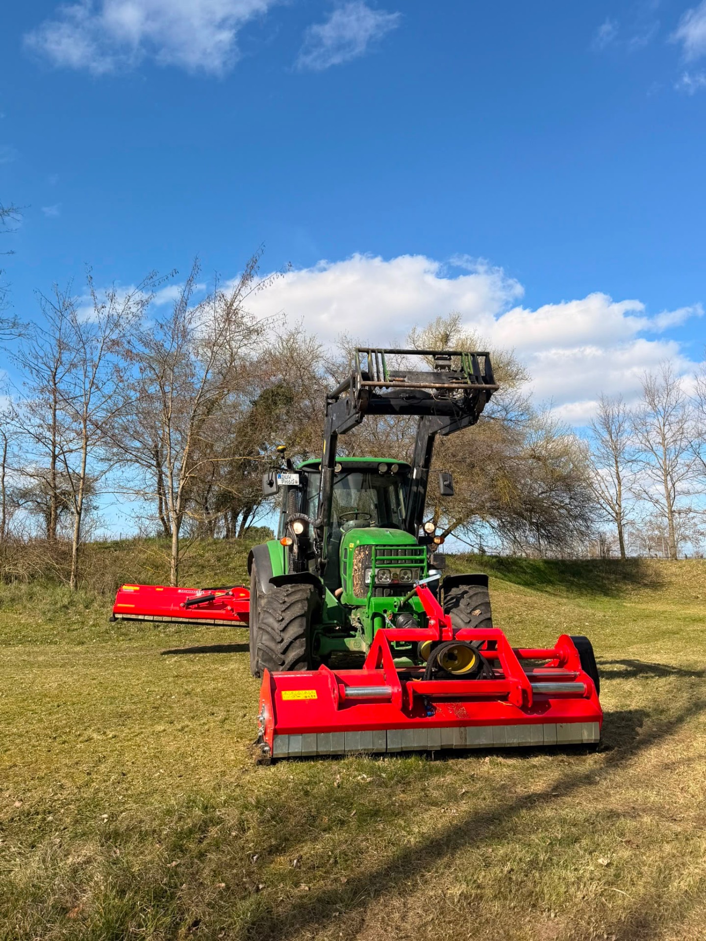 John Deere mit Mulcher auf der Wiese