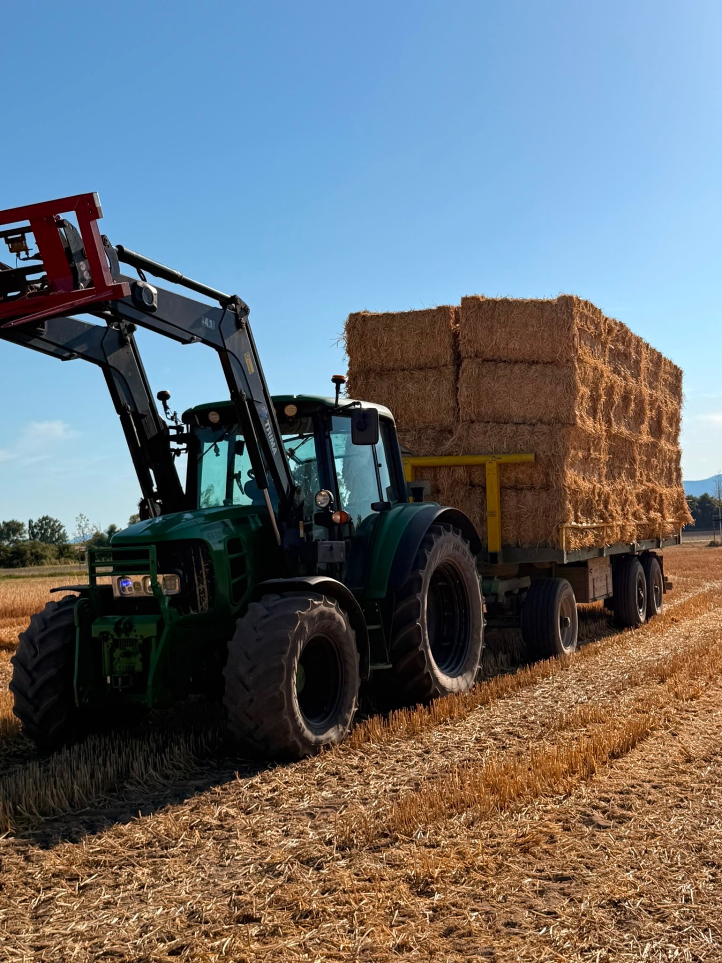 Traktor mit gestapelten Strohballen